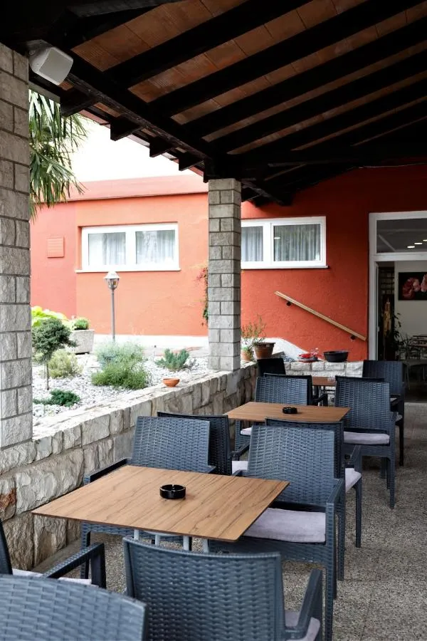 Mize na terasi pod nadstreškom in vhod v hostel