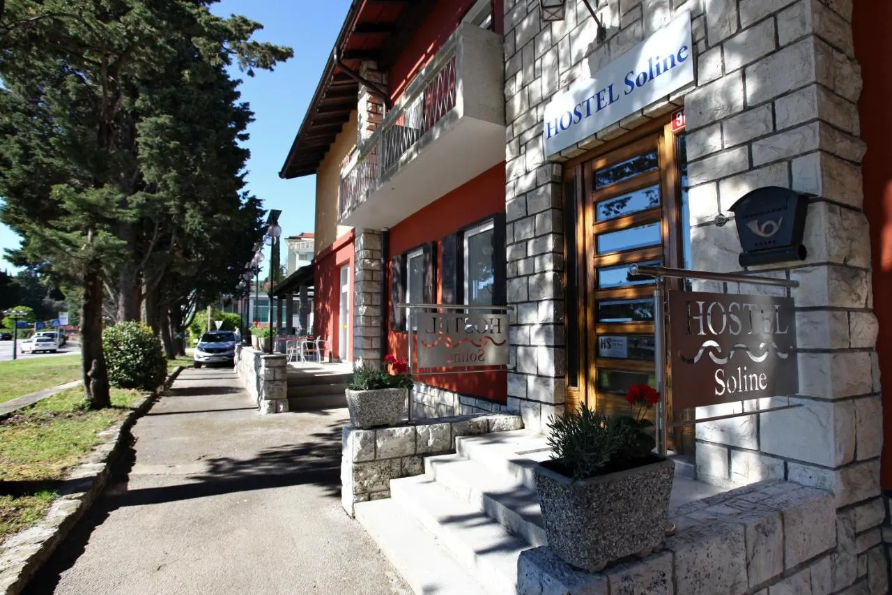 Hostel Soline z ulice: kamnit vhod in napis ob drevoredu